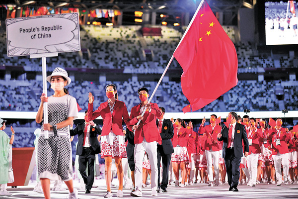 ●排球女將朱婷與跆拳道好手趙帥持旗引領中國代表團入場。 新華社