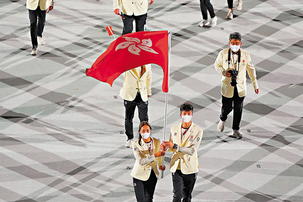 ●中國香港隊羽毛球手謝影雪（左）與劍擊運動員張家朗持旗進場。 新華社