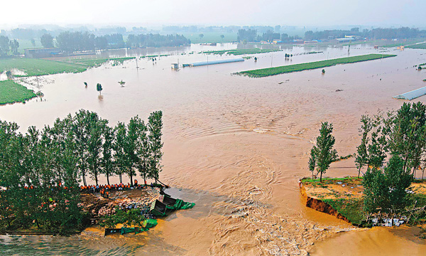 ● 23日，位於河南省鶴壁市浚縣馬頭村附近的衛河鶴壁段堤壩出現近40米長決口，決口處已填入數車石料及多輛大卡車。 中新社