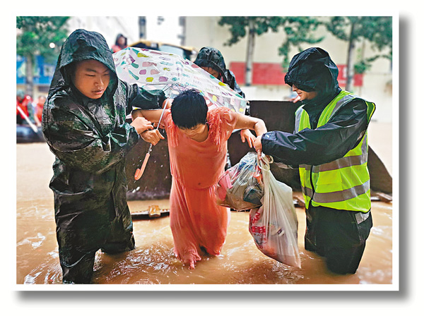 ●22日，河南新鄉軍分區民兵在轉移受災群眾。 新華社