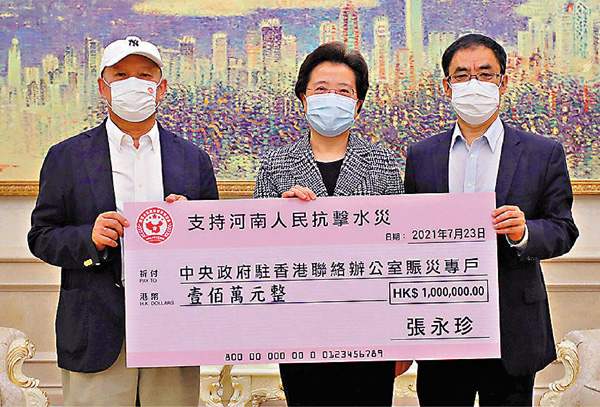 ● 張永珍個人捐款100萬元，中聯辦副主任仇鴻（中）代表接收。香港文匯報記者  攝