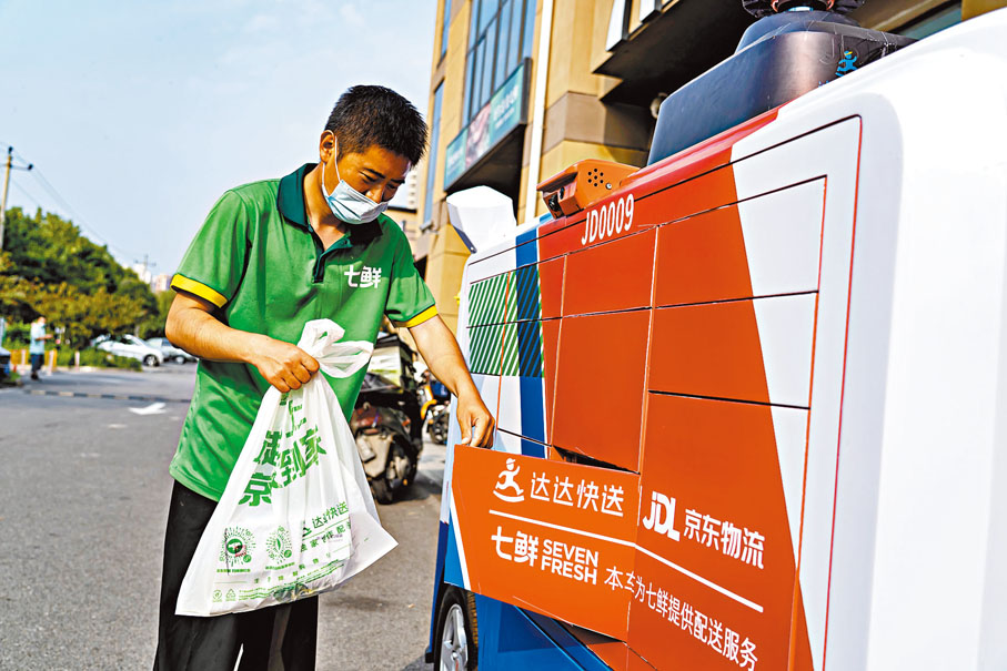 ● 工作人員將網購貨物放入無人配送車中。 受訪者供圖