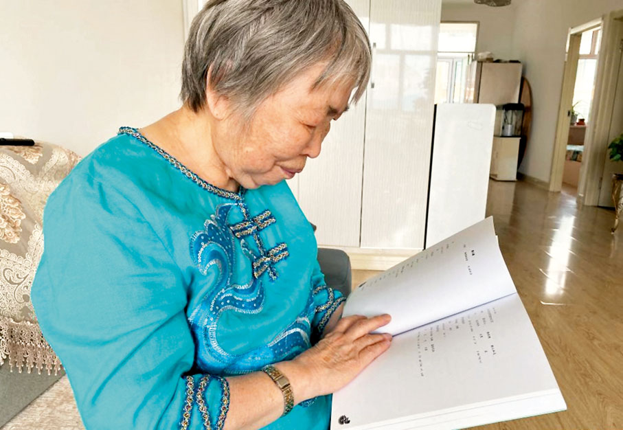 尤金蘭在翻看自己編寫的赫哲語教材。