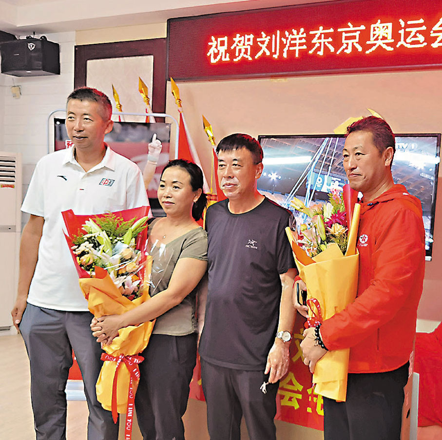 ●劉洋父母（右二、右三）與啟蒙教練孔繁啟（右）在鞍山市軍事體育學院的慶祝現場合影。 受訪者供圖