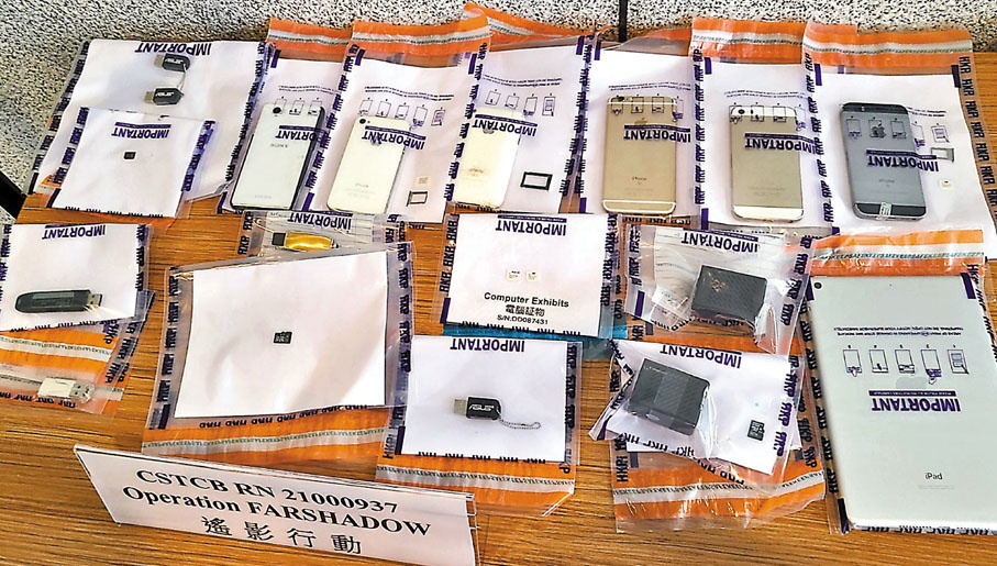 ●警方展示行動檢獲的多部電腦、手提電話、電話卡及拍攝工具等證物。