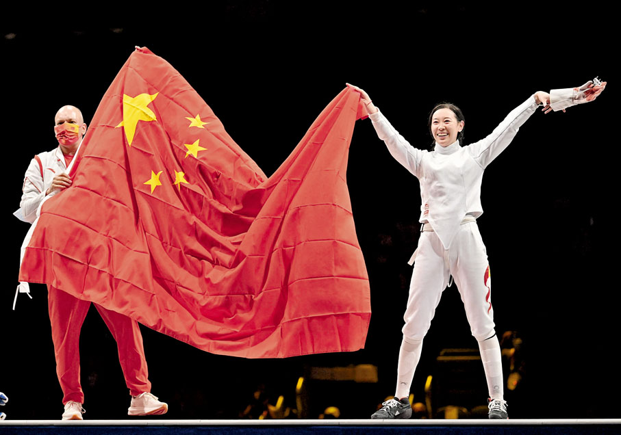●歐伯利（左）在孫一文東奧女子重劍奪冠後第一時間和愛徒一起展開中國國旗。   法新社