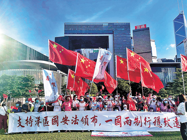 ● 香港國安法實施一年多，社會重回正軌，市民生活安寧，開啟了由亂及治的新局面。圖為一群愛國愛港市民自發支持香港國安法頌布。 資料圖片