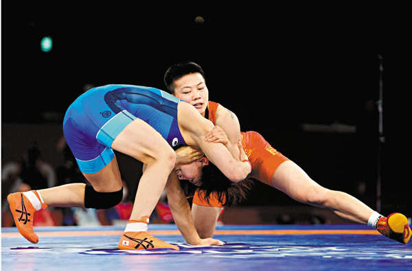 ●龐倩玉(右)在摔跤比賽中與對手角力。  新華社