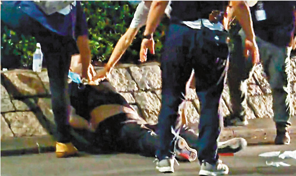 ●屯門謀殺案疑兇被捕後坐在現場。 電視截圖