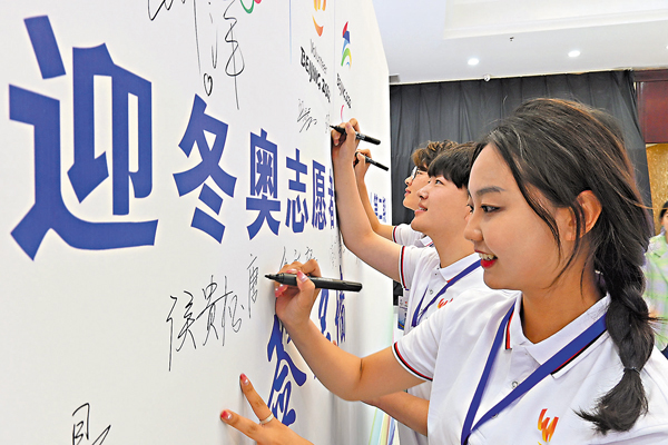 ●再過整整180天，明年立春之日，北京冬奧會將拉開帷幕。圖為參會志願者在活動牆上簽名。  資料圖片