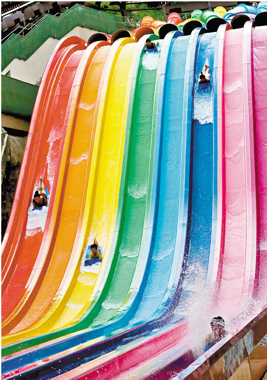 泳客玩「八彩天梯」時需趴在俯衝式滑行墊上從高處滑下。 香港文匯報記者  攝