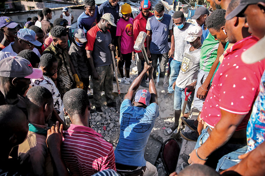 ● 災民用簡單工具搜索生還者。 美聯社