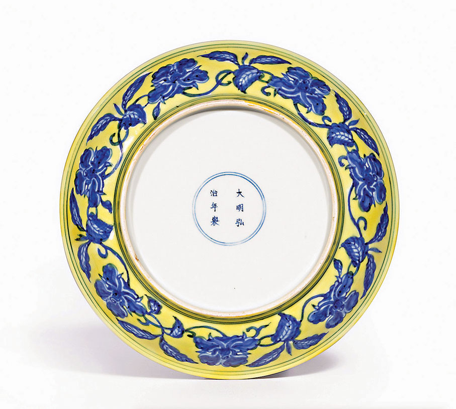 ●明弘治黃地青花梔子花紋盤。圖片來源：香港佳士得