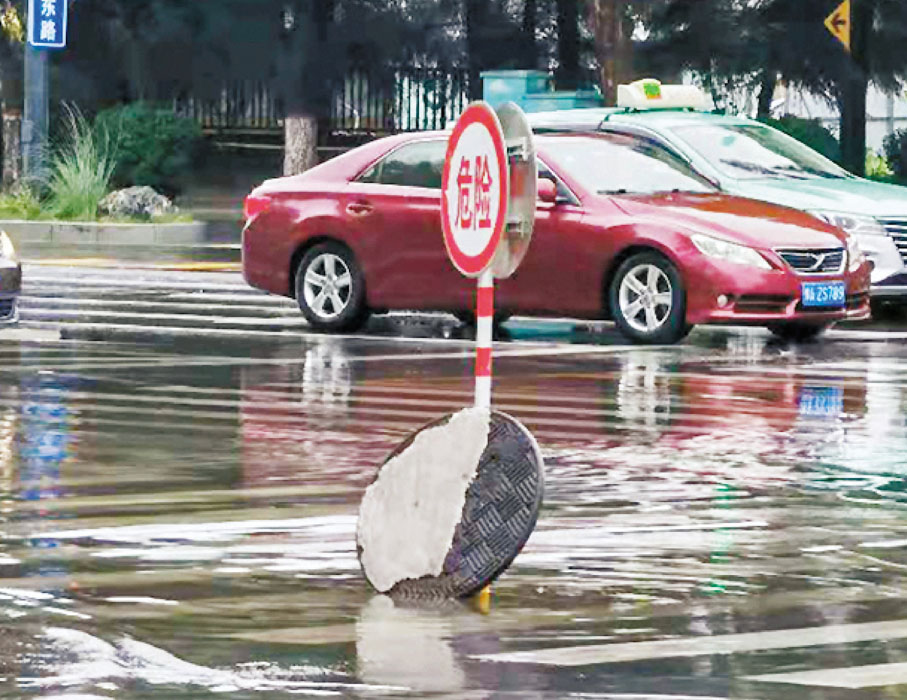 ● 22日，鄭州街頭的窨井蓋全部打開以防積水。 香港文匯報記者劉蕊  攝
