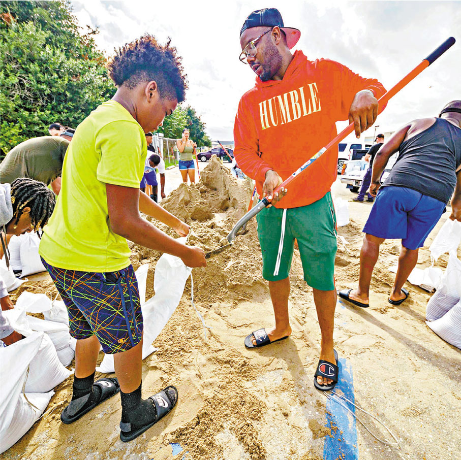 ●人們填滿沙包防範颶風。 美聯社