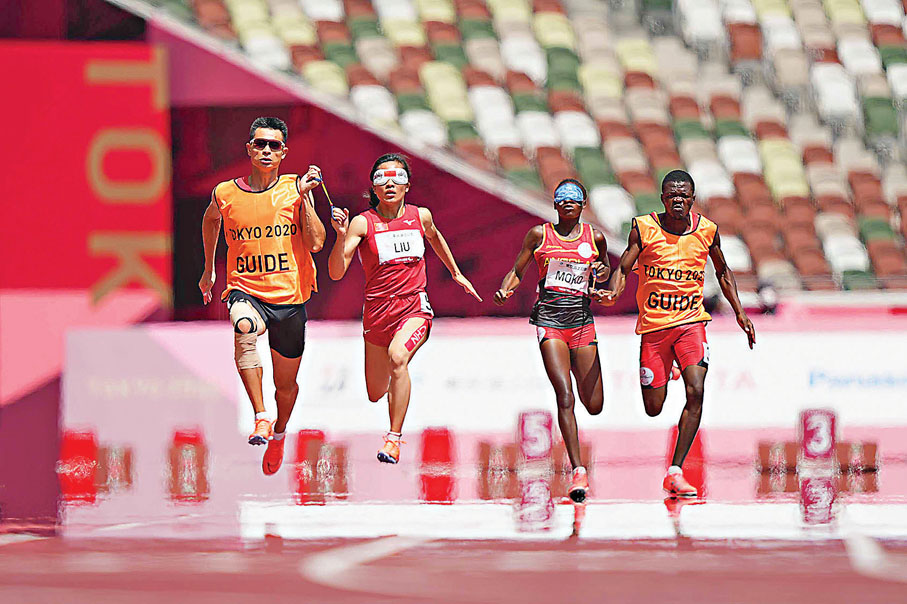 ●「視障女飛人」劉翠青（左二）和領跑員徐冬林（左一）在比賽中。