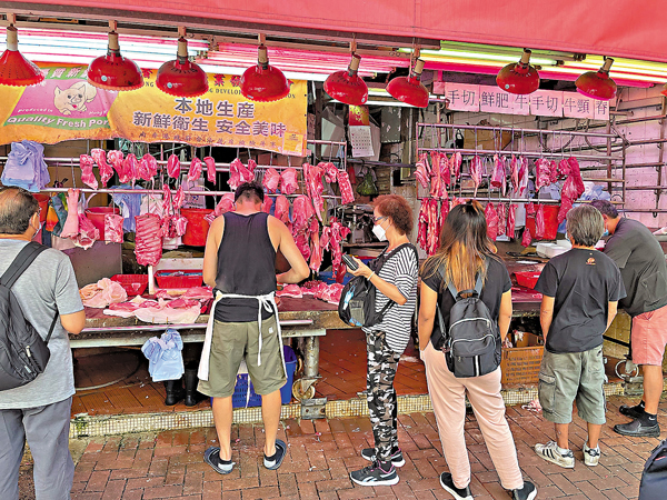 ●小西灣野豬染疫並未影響市民購買豬肉熱情，銅鑼灣一間豬檔多人排隊等待買豬肉。香港文匯報記者  攝