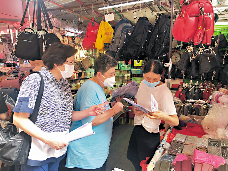 ●王少華（左）、陳聰聰（中）昨日在北角街站介紹「愛國者治港」原則。