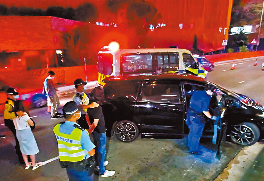 ●被捕兩男女在車邊協助警員搜查涉案車輛。