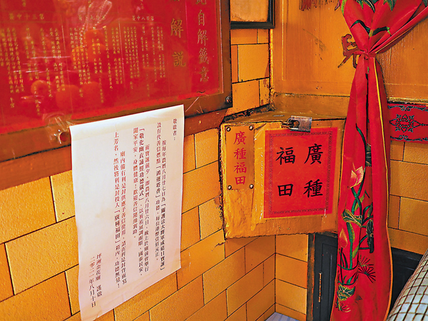 ●金花廟內貼有收取費用代善信燃點塔香的通告，並設有收款箱。 香港文匯報記者  攝