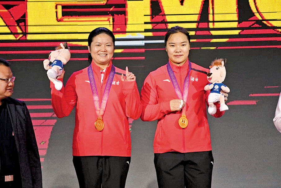 ●向艷梅（右）和教練周繼紅獲頒金牌。 香港文匯報西安傳真