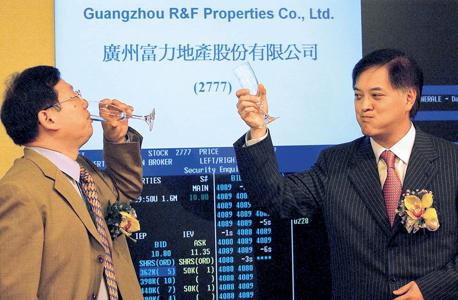 ●李思廉（右）與張力（左）在2005年為富力地產在香港上市舉杯慶祝，如今則為公司提供約80億元股東資金。 資料圖片