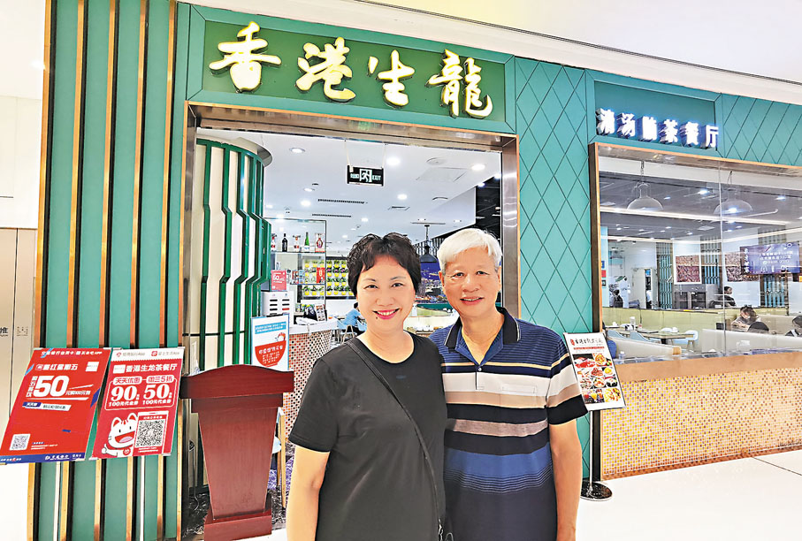 ●伍銅與夫人在「香港生龍」茶餐廳長沙國金中心店前留影。 香港文匯報記者姚進 攝