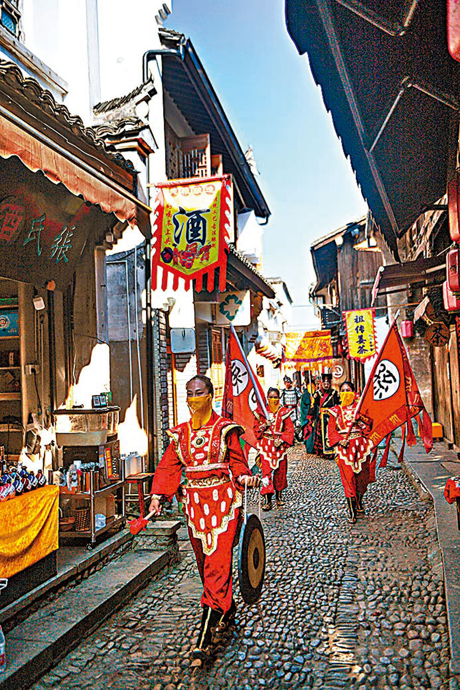 ●龍門古鎮《孫權迎賓》實景演出的演員在古鎮內巡街。