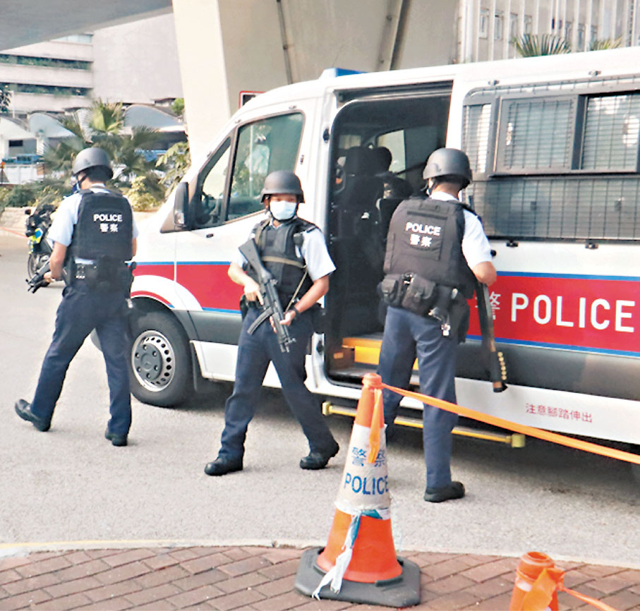 6名前《蘋果日報》高層昨日由囚車押解到庭應訊，大批身穿避彈衣、荷槍實彈的警員在法院外戒備。 香港文匯報記者  攝
