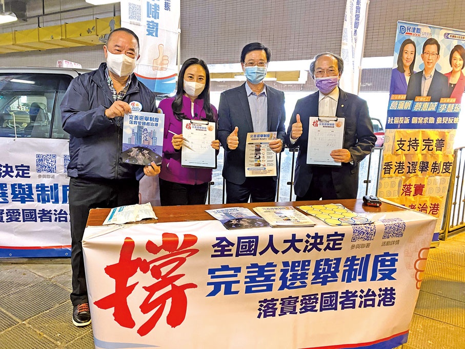 ● 2021年3月13日，余鵬春（左一）在香港街頭支持全國人大關於完善選舉制度的決定。