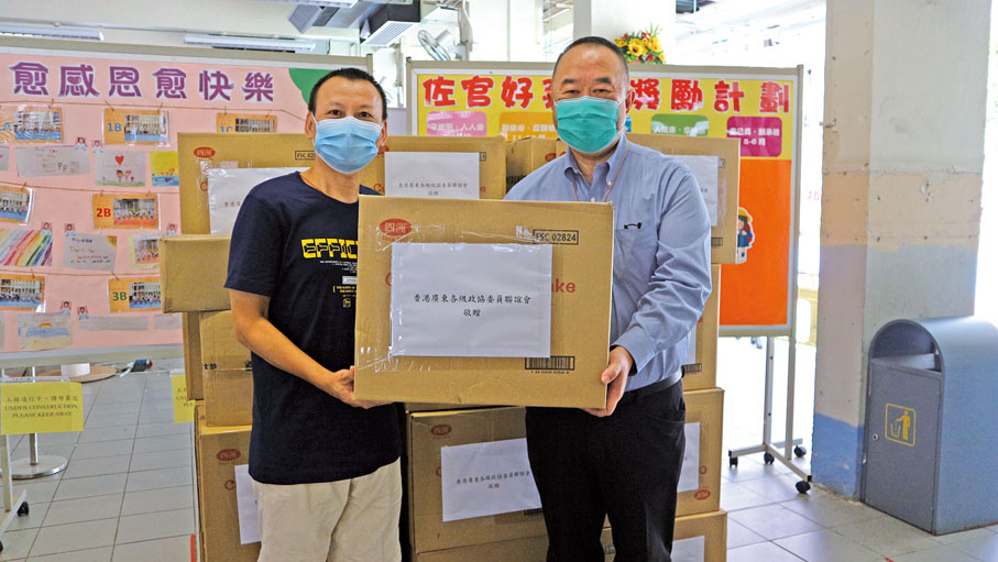 ● 2020年7月，余鵬春（右）代表香港廣東各級政協委員聯誼會向佐敦官立小學師生捐贈抗疫物資。