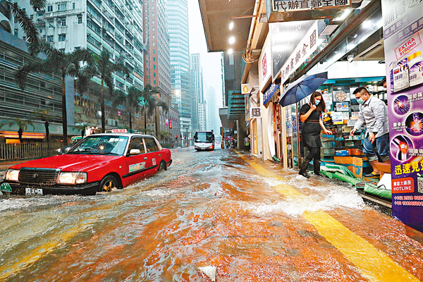●受熱帶風暴「獅子山」及東北季候風夾擊，香港天文台昨日發出黑雨警告，港島多處成水浸「重災區」。圖為灣仔街道變成河流，水淹商舖，車輛涉水行駛。 香港文匯報記者  攝