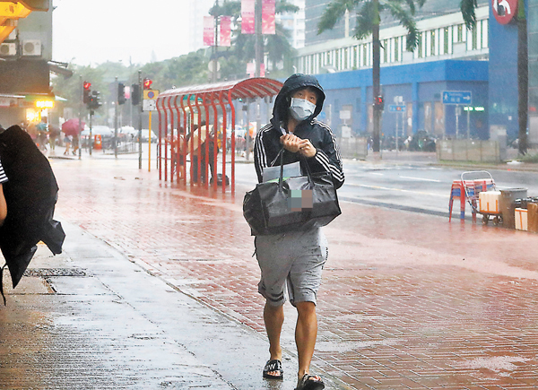 ●八號風球下，外賣員冒着狂風暴雨送外賣。香港文匯報記者  攝