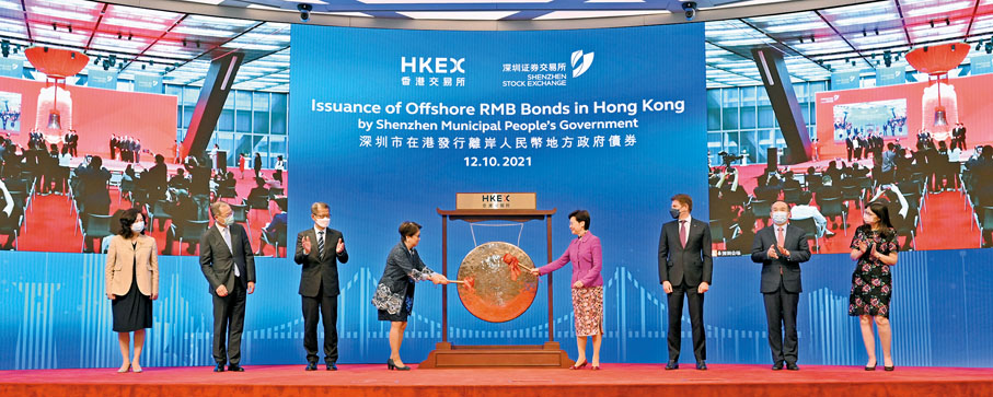 ● 深圳市政府在港發行離岸人民幣債券敲鑼儀式昨於港交所香港金融大會堂舉行。圖為林鄭月娥（右四）與史美倫（左四）共同敲鑼。 政府新聞處