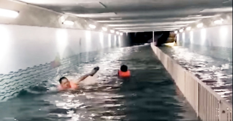 城門河●沙田城門河邊行人隧道被倒灌海水淹浸，兩名男子在水中「暢泳」苦中作樂。視頻截圖