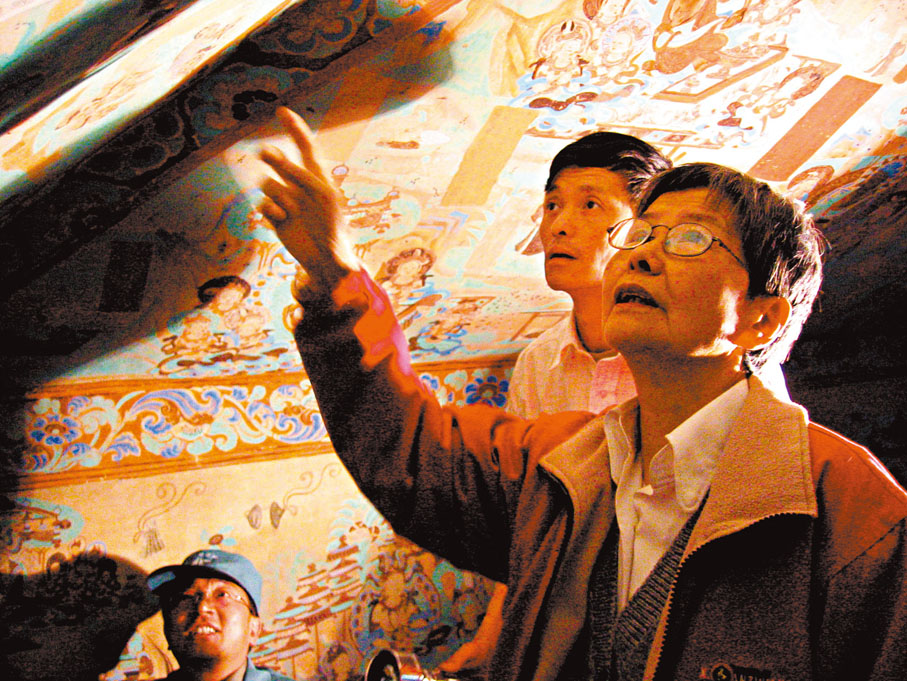 ●樊錦詩和壁畫保護技術人員討論細節。