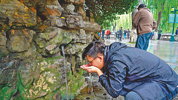 ●周澤眾在黑虎泉取水點品嚐泉水。香港文匯報記者胡臥龍  攝