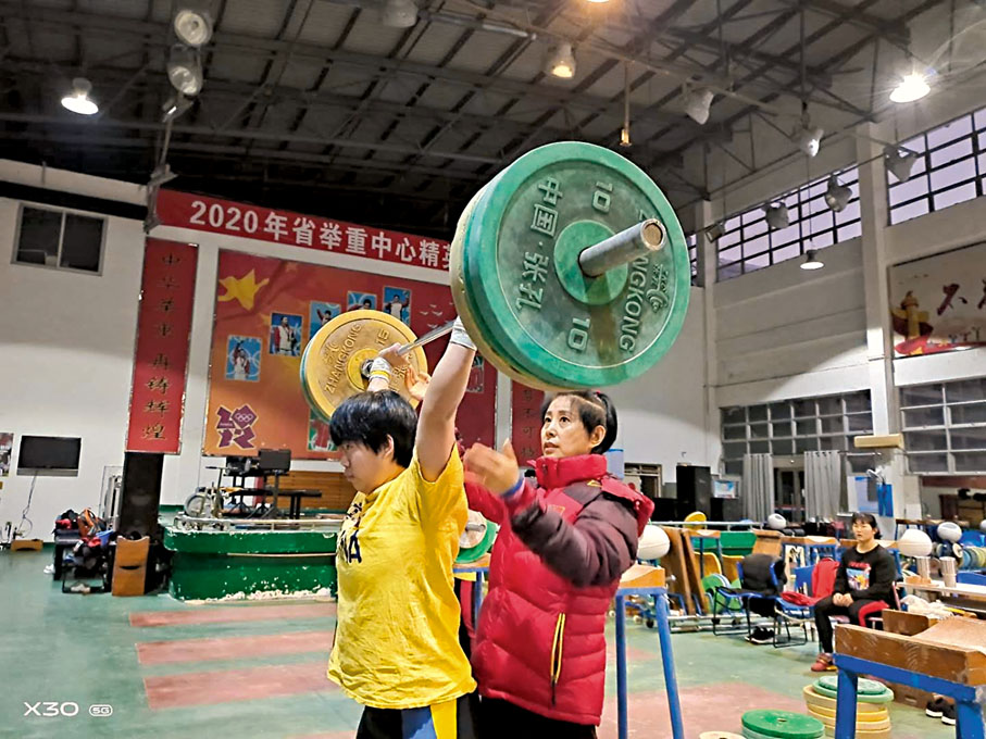 ● 舉重教練關詠梅在指導運動員訓練。受訪者供圖
