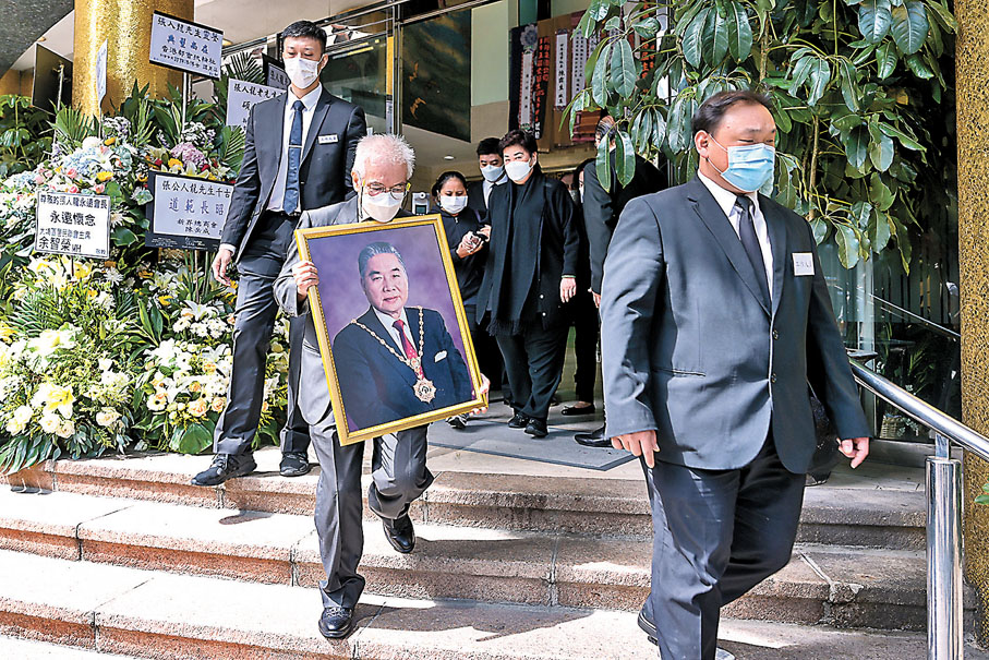 ●上月離世的張人龍大殮儀式昨日在香港殯儀館舉行。圖為家屬捧着張人龍的遺照步出靈堂。 中新社