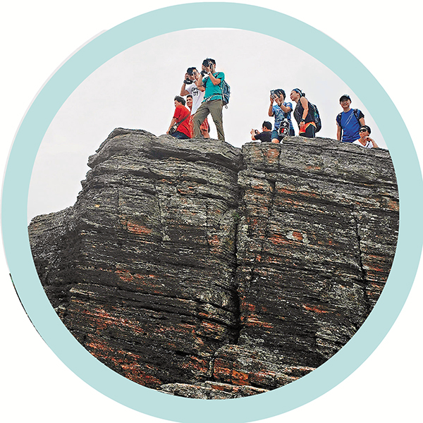 ● 遊客在香港東平洲的一處海蝕柱上拍照。資料圖片