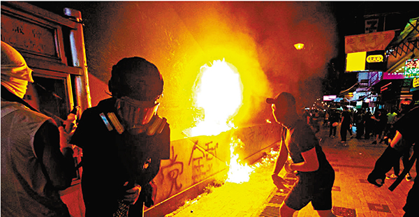 ●黑暴期間不時有暴徒在深水埗街頭縱火，圖為黑衣暴徒以汽油彈攻擊港鐵深水埗站。資料圖片