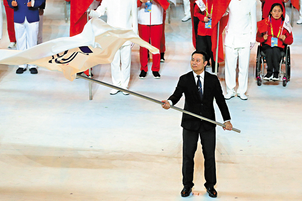 ●特區民政事務局局長徐英偉接過殘運會會旗。  中新社