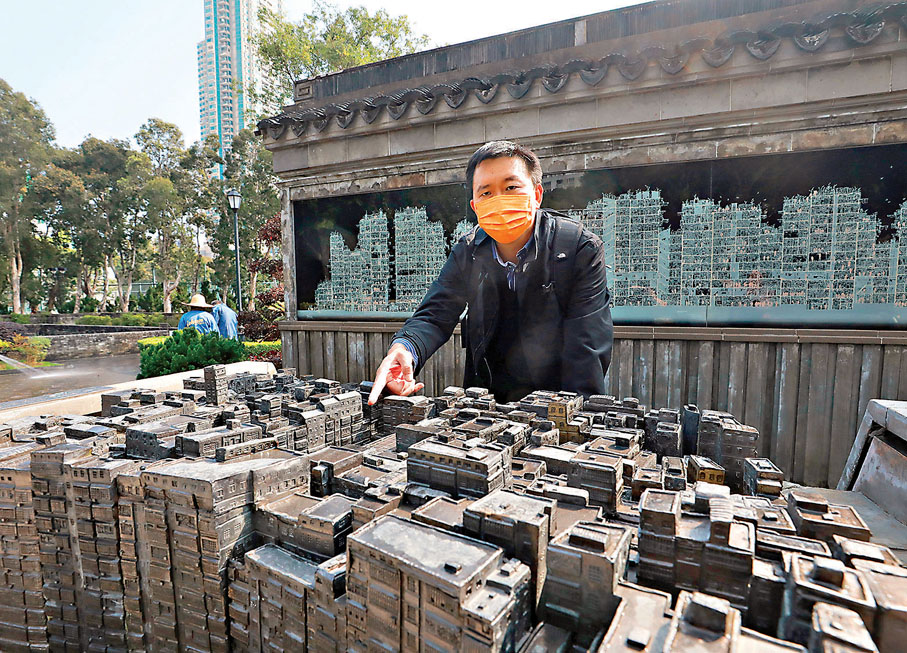 ● 如今的九龍寨城已被清拆，惟有模型還保留着幾分舊時模樣，邱逸手指城寨的方位為記者講述昔日的歷史。 香港文匯報記者  攝