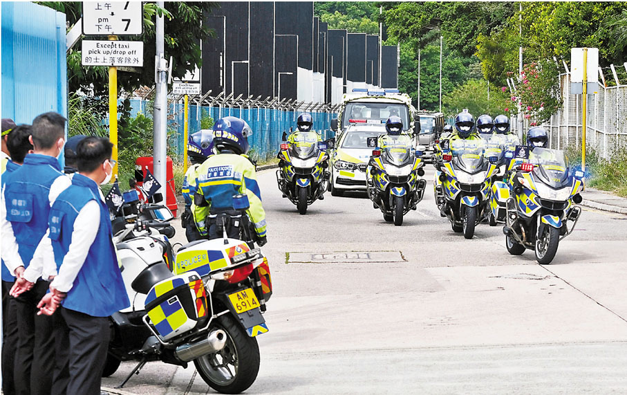 ●靈車由警察護送隊開路抵達昂船洲小艇基地路祭。 香港文匯報記者  攝