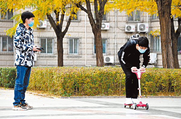 ● 11月3日，在北京航空航天大學學院路校區附近的一片開闊場地上，北京航空航天大學飛行器適航工程系副教授柯鵬的碩士研究生張藝鳴（右）和劉暢飛進行助推器實驗。   新華社
