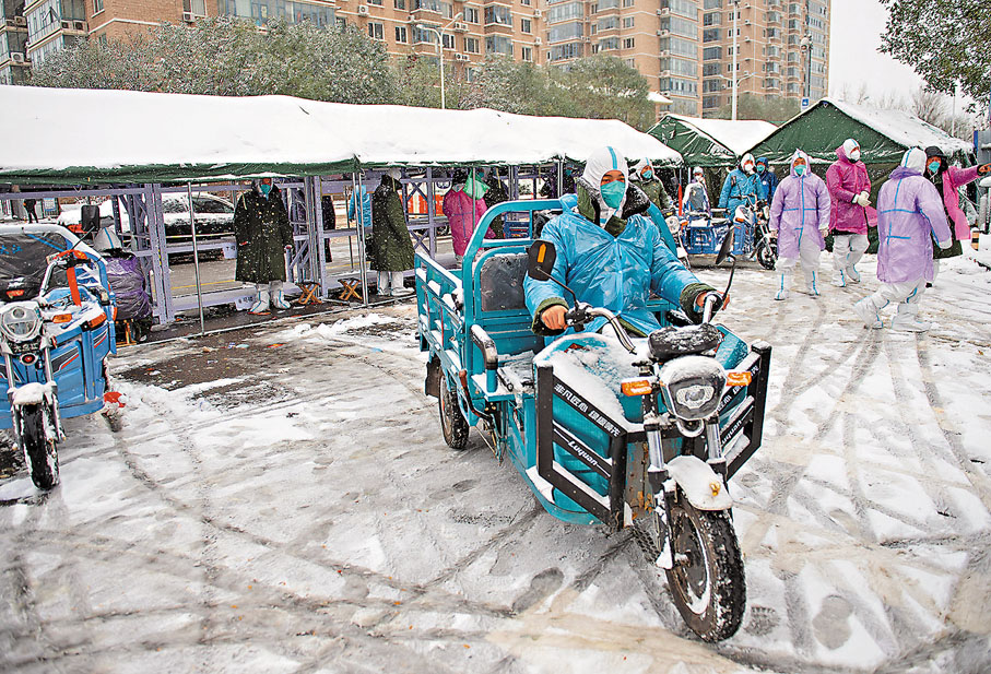 ●11月7日，在處於封控管理下的北京市昌平區天通北苑第二社區一處入口，工作人員駕駛三輪車運送居民的快遞包裹。新華社