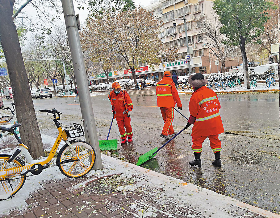 ●11月7日，北京環衞工人正在清理路邊積雪及落葉。 香港文匯報記者江鑫嫻 攝