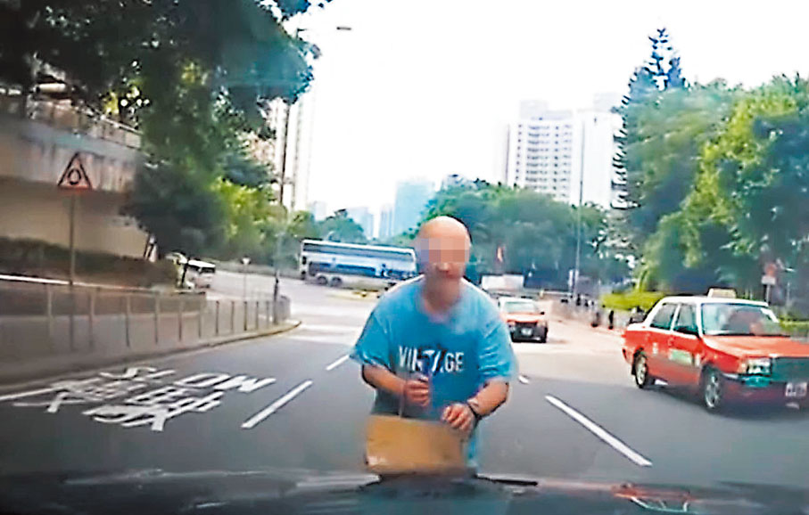 ●片段所見，光頭漢從馬路中線衝向車頭，司機及時停車，光頭漢一度呆站車前。 網片截圖