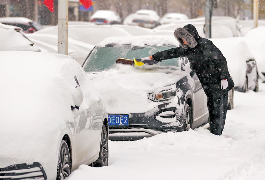 ●11月8日，瀋陽市民清理汽車上的積雪。  中新社