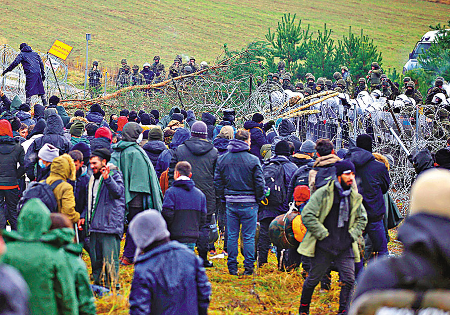 ● 非法移民企圖越過圍欄，波蘭軍方嚴陣以待。 美聯社